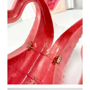 Macro shot of gold hinges and pink marble acrylic material on luxury evening clutch