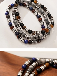 Macro detail of natural tiger eye and marble stone beads with metallic spacers on a bracelet