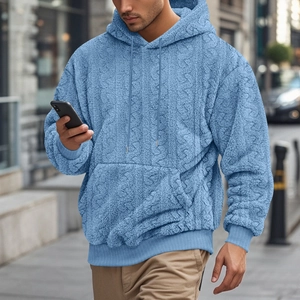 Outdoor shot of men's blue teddy fleece hoodie showing textured fabric and urban style