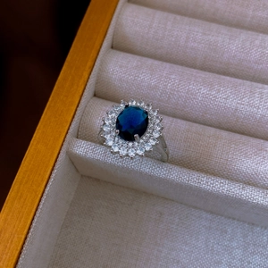 Dettaglio macro di anello ovale stile zaffiro blu reale con zirconi in scatola regalo