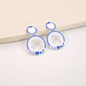 Detailed view of blue and white porcelain style acrylic earrings with geometric double circles