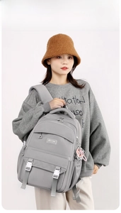Detail of light gray water-resistant nylon backpack with multiple compartments and zippers