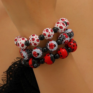 Ensemble de trois bracelets extensibles avec coccinelles et cœurs portés au poignet