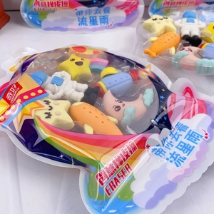 Close-up of space-themed erasers with astronaut, rocket, and moon shapes in packaging