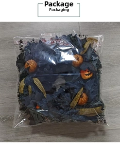 Detail of Halloween black maple leaf wreath with orange glitter pumpkins in clear packaging