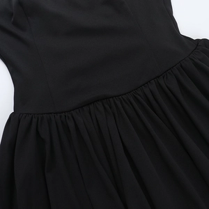 Close-up of high-quality pleated waist detail and stitching on black cocktail dress