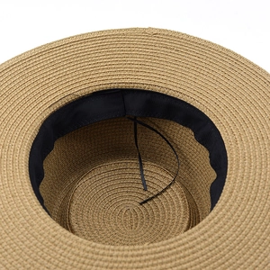 Close-up of woven straw hat interior with black sweatband and adjustable drawstring
