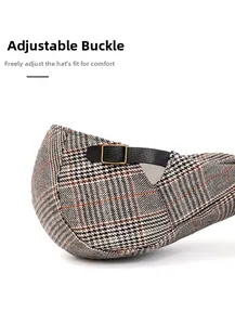 Detail of adjustable leather strap and bronze metal buckle on vintage plaid beret hat