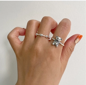 Close-up of a minimalist 925 silver ring set featuring a 3D bear charm and heart beads