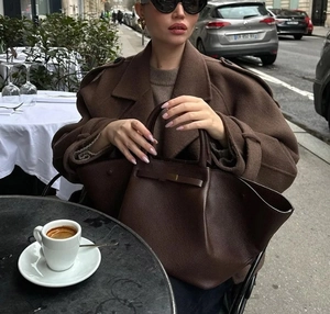 Gros plan sur la texture du cuir grainé marron foncé d'un sac cabas minimaliste
