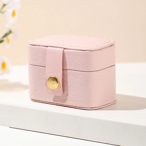 Close-up of pink jewelry box featuring fine cross-grain texture and golden button