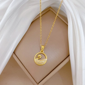Elegant gold hollow swan necklace with sparkling crystals on a white silk background