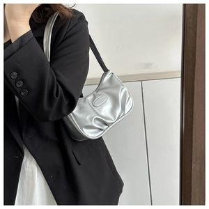 Silver metallic baguette bag with pleated texture shown in a trendy mirror selfie