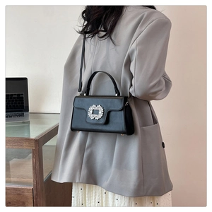 Vue détaillée d'un sac à bandoulière noir en cuir PU avec boucle en cristal sur le mannequin