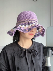 Close-up of handmade purple crochet sun hat with a bohemian woven pattern on the brim