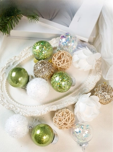 Detail of white and green Christmas balls with sequins, flocking, and woven textures