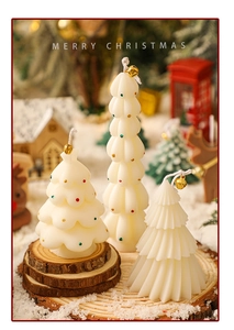 Close-up of white mini Christmas tree candles with bells on rustic wood discs