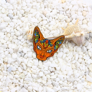 Sphynx cat enamel pin with colorful totem patterns on white pebble background