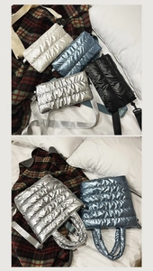 Detail of quilted glossy tote bags in metallic silver and blue on a soft plaid blanket