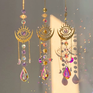 Detailed view of three gold crystal suncatchers casting rainbow light on a neutral wall