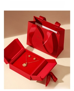 Detail of red jewelry gift box set with golden necklace and matching gift bag