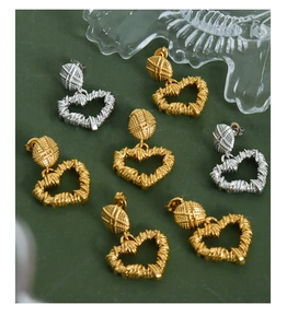 Detailed macro view of vintage twisted texture heart earrings in gold and silver finish
