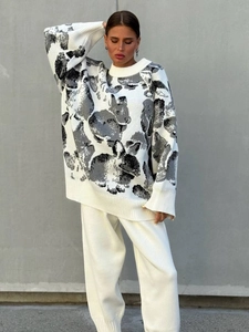 Cozy white long-sleeve knit sweater with black rabbit patterns and crew neck design