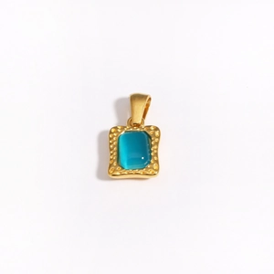 Close-up of a square gold pendant featuring a hammered texture and a blue gemstone inlay