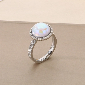 Macro shot of silver titanium ring with iridescent gemstone and small side diamonds