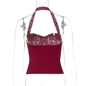 Close-up of retro dark red halter neck top with white polka dots and pleated chest detail