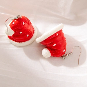 Detail showing red Christmas hat earrings with white polka dots on a soft white fabric