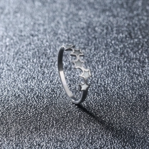 Macro view of minimalist silver star band ring with connected five-pointed star patterns