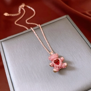 Detail of pink teddy bear pendant with red heart stone on a luxury gift box
