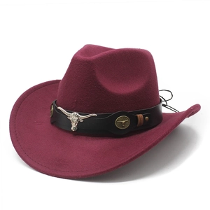 Macro detail of burgundy cowboy hat featuring leather belt and silver bull head ornament