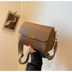 Détail de sac bandoulière marron foncé en cuir avec large sangle à motifs ethniques
