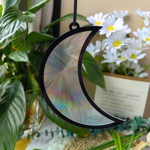 Detail of crescent moon suncatcher with holographic film reflecting rainbow light