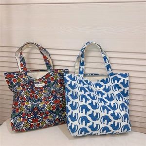 Detail of floral and cat print cotton canvas tote bags with smooth zipper closures