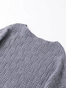 Close-up detail of grey off-shoulder knit sweater showing basket weave texture and neckline