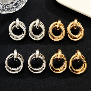Detailed view of intertwined geometric hoop earrings with matte and polished textures
