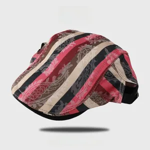 Détail d'une casquette plate à rayures rouges et noires avec motifs paisley et maille fine