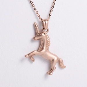 Detailed close-up of rose gold unicorn pendant with sandblasted finish on white surface