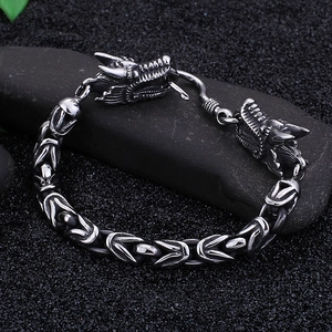 Macro detail of gothic dragon head hook and braided stainless steel chain link