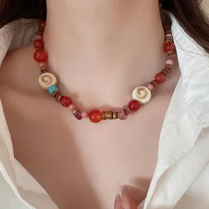 Bohemian beaded necklace with red agate, pink stones and wood beads on a female model