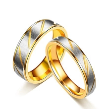 Detailed view of silver brushed and gold polished stainless steel couple rings