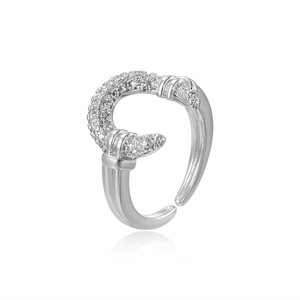 Macro shot of silver crescent moon ring with sparkling zircon inlays on white background