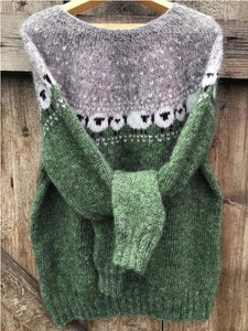 Detail van een grijs-groene gebreide trui met witte schapen jacquard patronen erop