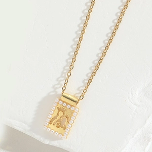 Detail of gold necklace pendant with pearl border and hollow mother-child silhouette