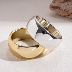 Minimalist wide geometric bangles in gold and silver finish on a natural stone base
