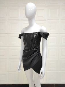 Détail de la robe noire à épaules dénudées avec paillettes et texture en satin drapé