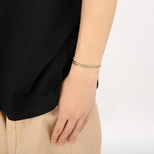 Detail of gold-plated Cuban link chain necklace worn on a model for casual styling